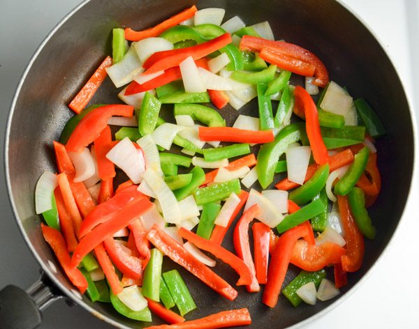 Heat oil in a large skillet over medium heat. Add pepper and onions. Cook 4 minutes.