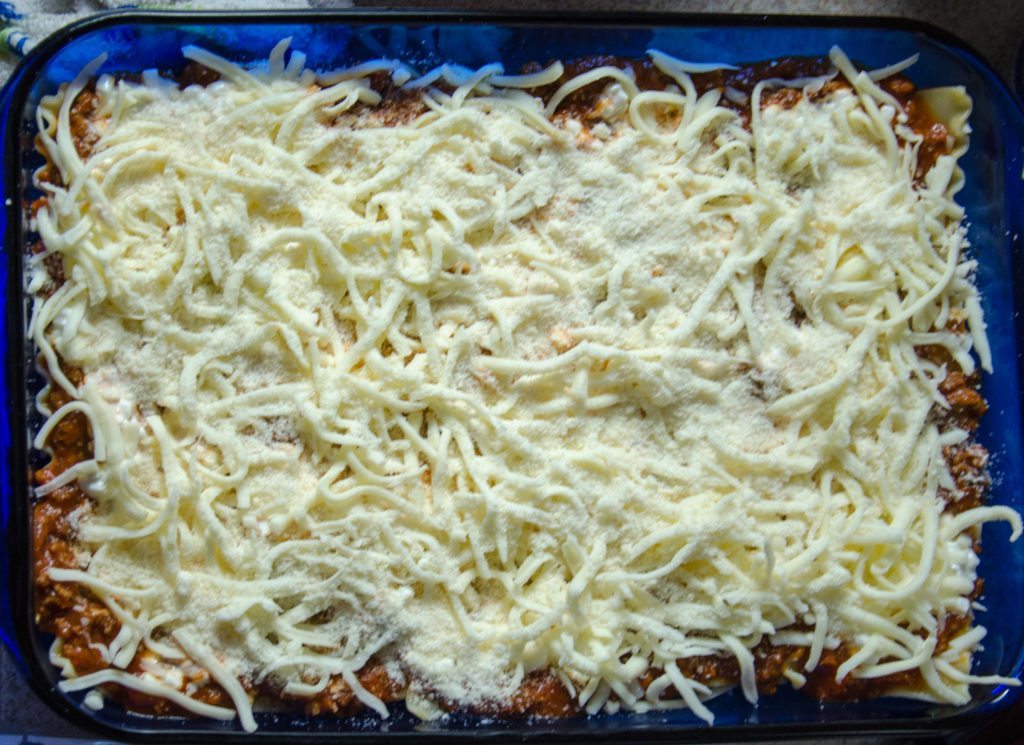 Sprinkle 1/3 of mozzarella and 1/3 of Parmesan.