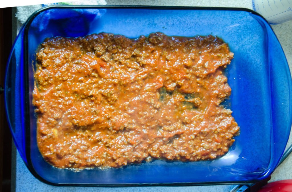 Cover bottom of pan with thin layer of meat mixture (meats, spaghetti sauce, spices).
