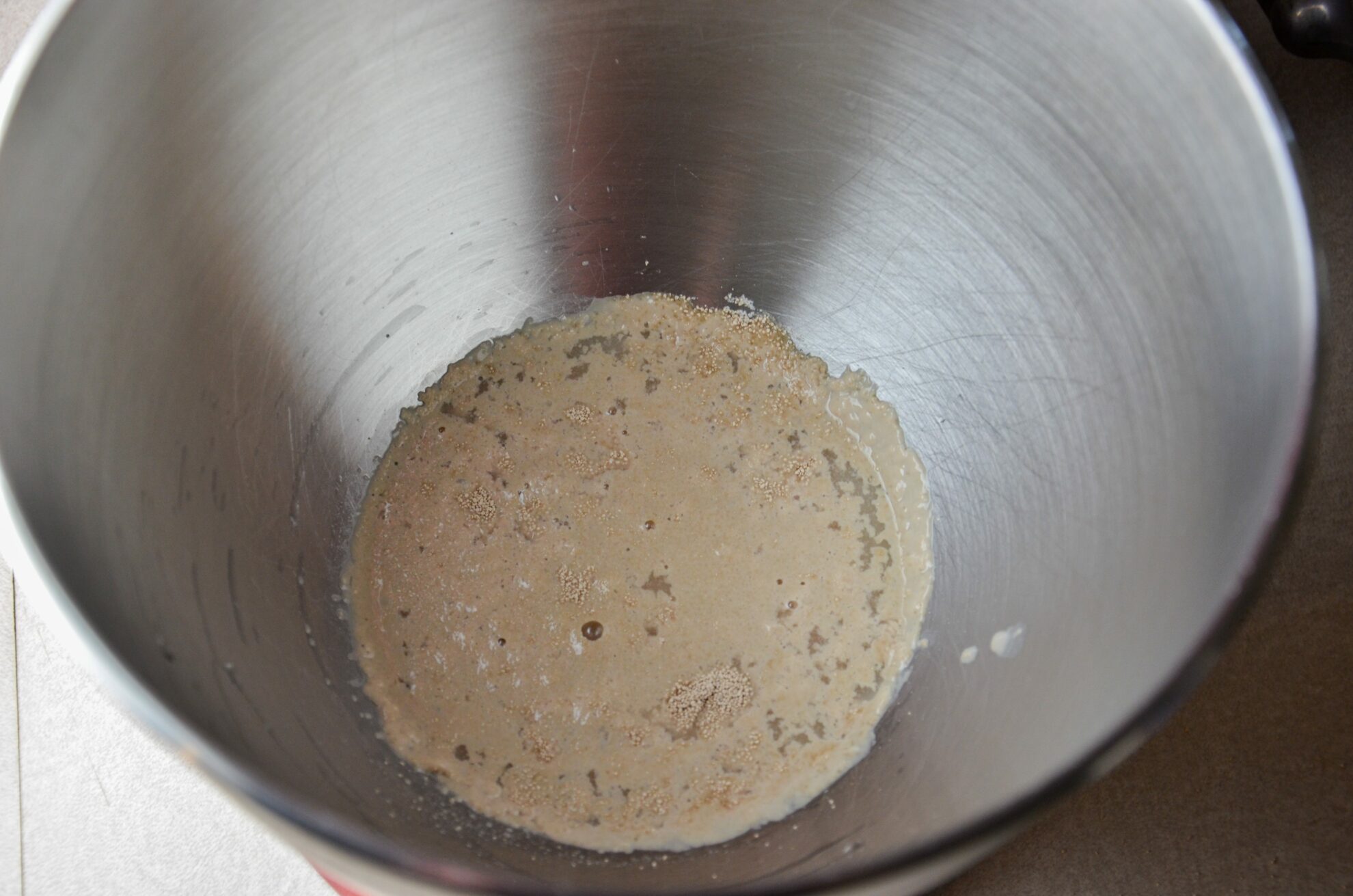 Combine the yeast, sugar, and 1/2 C. hot water in the bowl of a stand mixer. Let proof for 5-10 minutes.