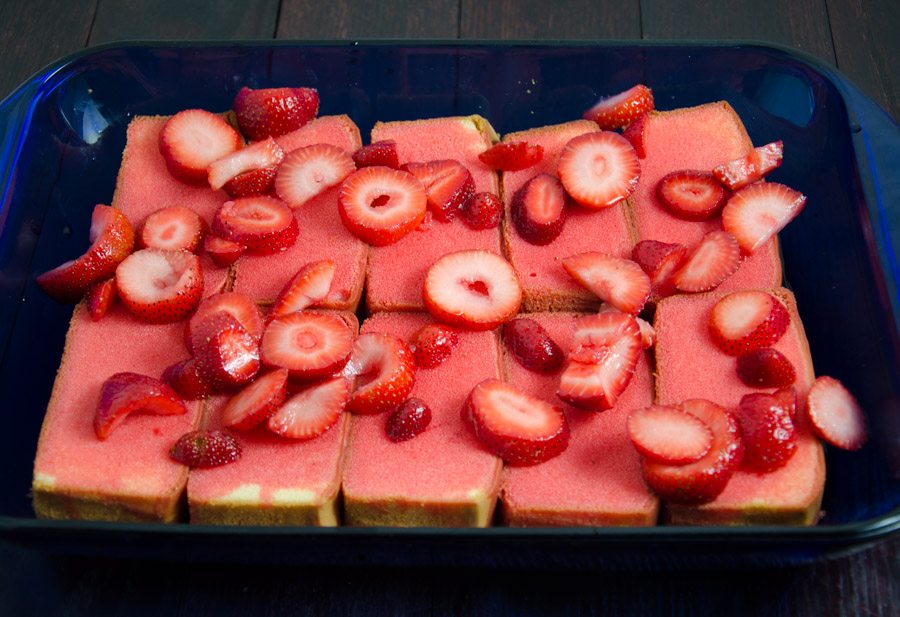 Pour strawberry jell-o and strawberry mixture over prepared pound cake. Allow to set.