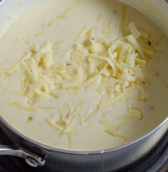LR_White Chicken Enchiladas_prep-14 Slowly add handfuls of cheese, stirring to combine as it melts. Use 2 to 2 & 1/2 cups of cheese, to taste. Set aside; cover to keep warm.