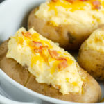 Entire dish of Twice-Baked Potatoes. Potatoes mixed with cheese, butter, sour cream, cream cheese, and bacon. Creamy, cheesy, delicious side dish that can be made in advance! #potatoes #twicebakedpotatoes #sidedish #bacon #cheese