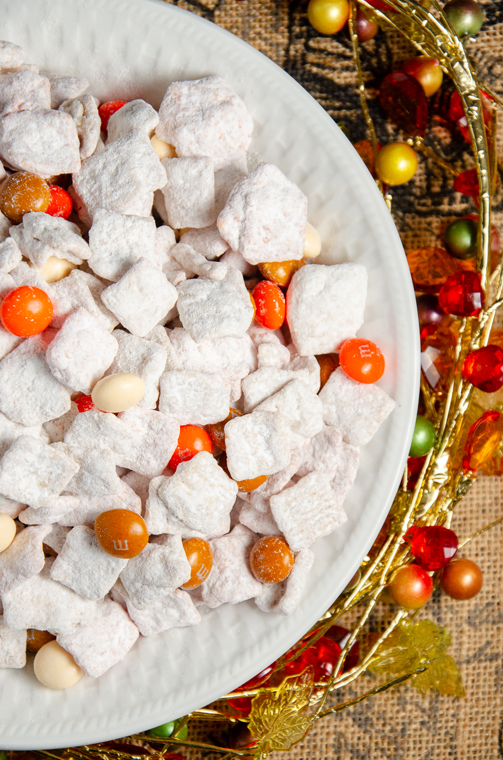 Vertical shot of Pumpkin Pie Spice Muddy Buddies. Cinnamon Toast Crunch, white chocolate, and pumpkin pie spice combine to make a delicious, easy, fall treat. #muddybuddies #puppychow #pumpkin #pumpkinspice #pumpkinpiespice