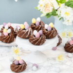 This mini chocolate bundt cake recipe is perfect for Easter. Made with a delicious chocolate batter and decorated with mini chocolate eggs. #bundt #minibundt #cake #Easter