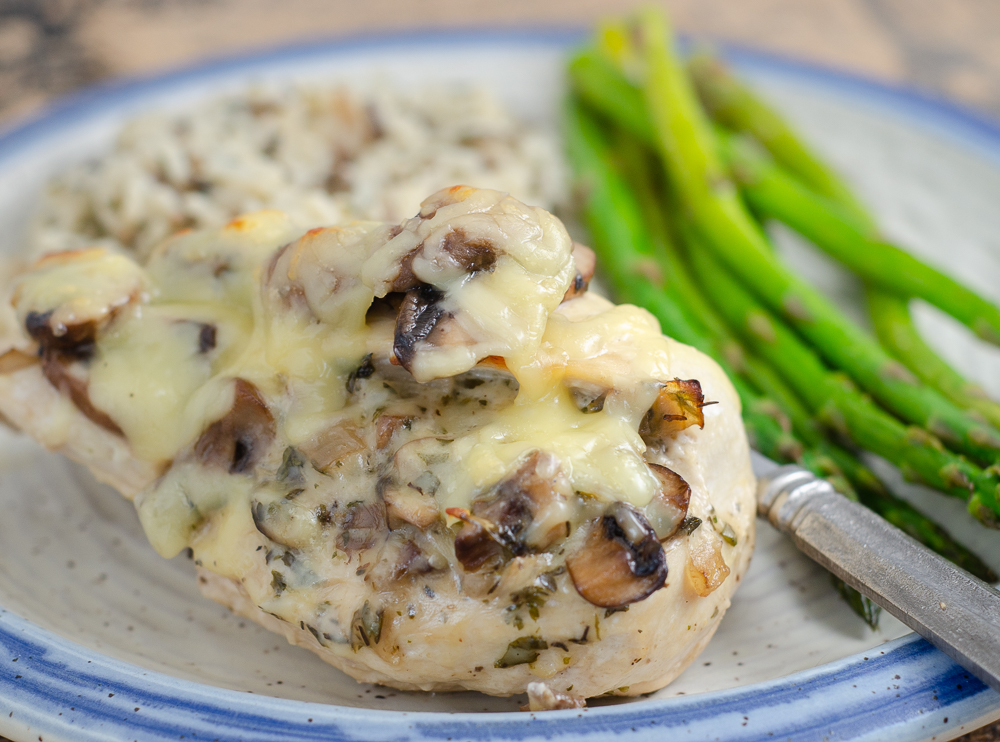 LR_Gouda Mushroom Chicken_2 Gouda and mushroom stuffed chicken with wild rice and asparagus on pottery plate.