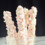 White chocolate peppermint pretzels vertical in a mason jar. Marble bottom and black background.