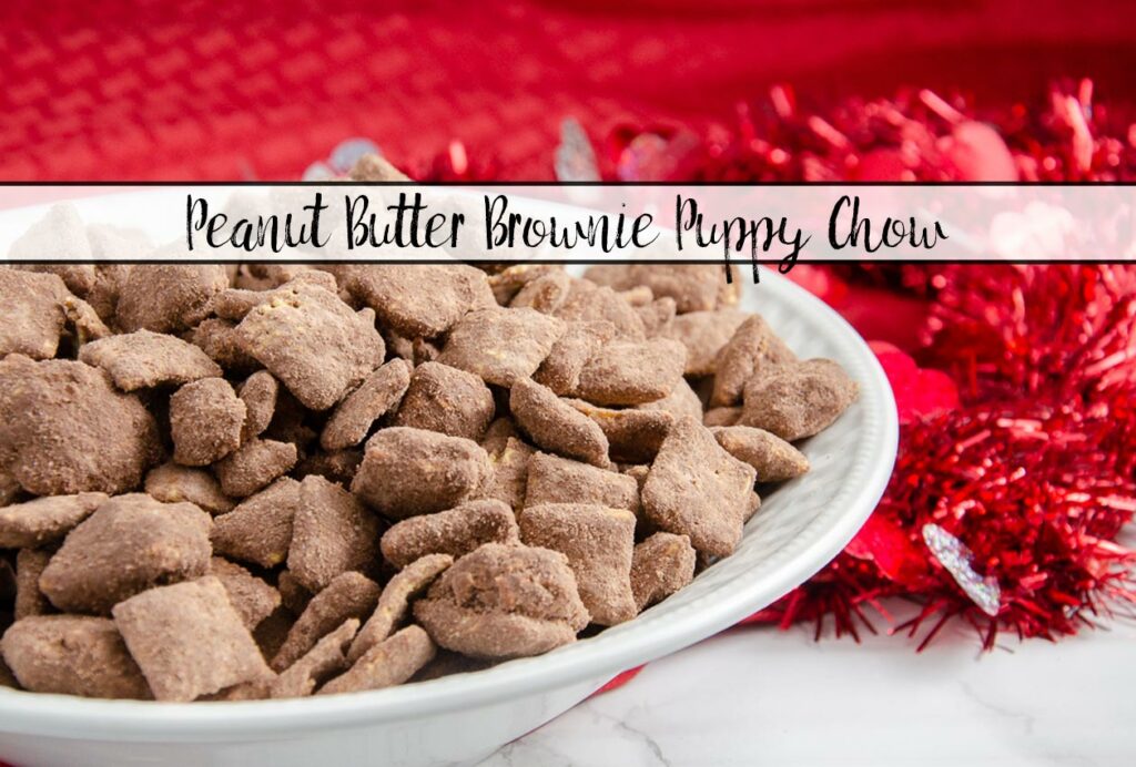 Featured mage of peanut butter brownie puppy chow. Puppy chow in white bowl with red cloth and white marble underneath.
