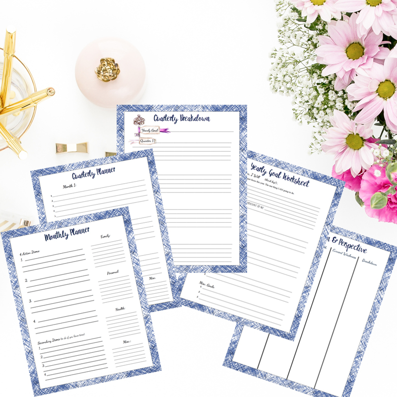 Goal worksheets in personal money management. Spread out with flowers and gold pens.