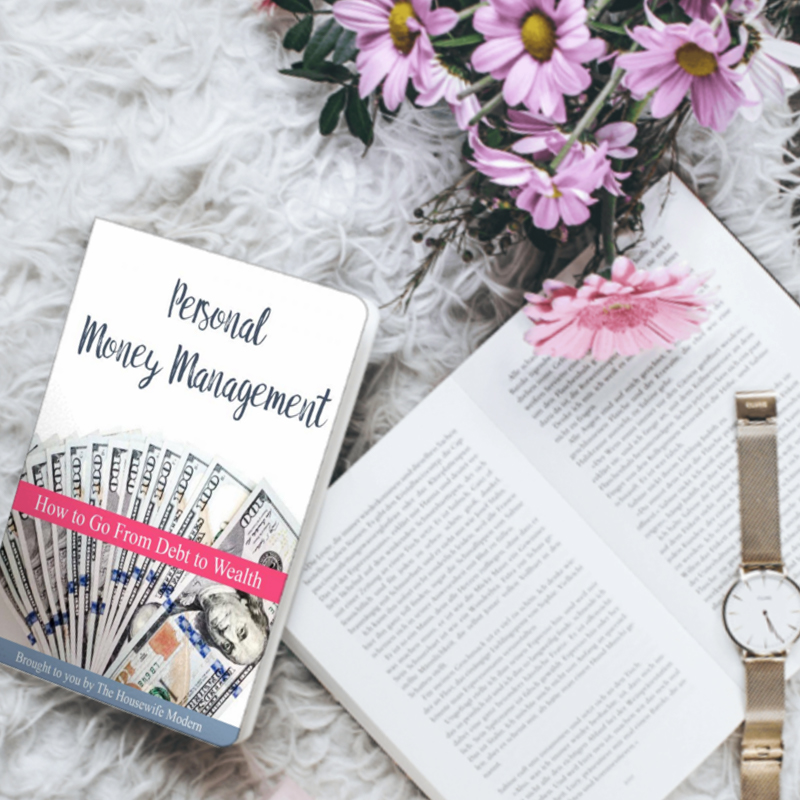 Image of personal money management book with flowers, book, and watch.