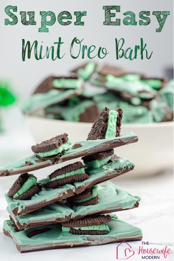 Pin image for mint oreo bark. Stack of mint oreo bark in foreground. White bowl full of mint oreo bark with green tinsel in background.