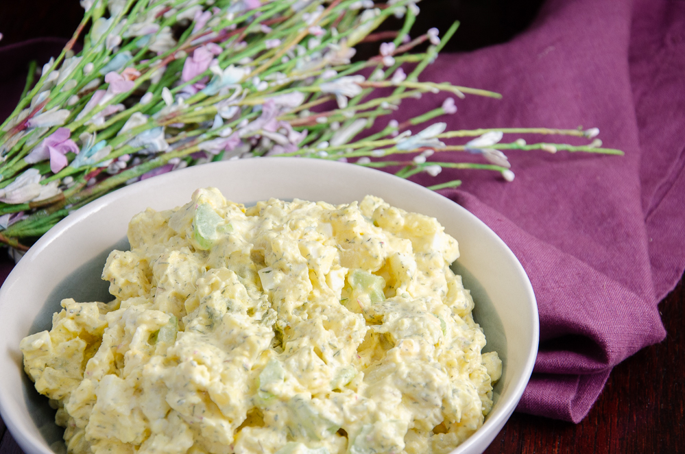 Featured image best classic potato salad. White bowl on purple napkin.