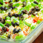 Vertical view of 7 layer dip. Clear dish, focus emphasized on front.