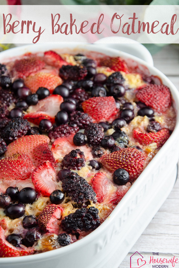 Pin image for triple berry baked oatmeal. Oatmeal in white casserole dish with white wood on