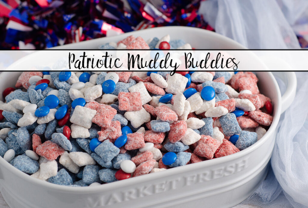 Featured image. Patriotic muddy buddies in white oval dish with sparkle wreath in background.