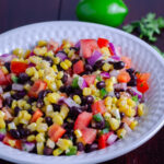 This quick and easy black bean and corn salad combines corn, black beans, tomatoes, jalapeños, red onion, red pepper, cilantro, and lime for a flavor-packed salad. No mayo, naturally gluten-free, and a healthy side dish.