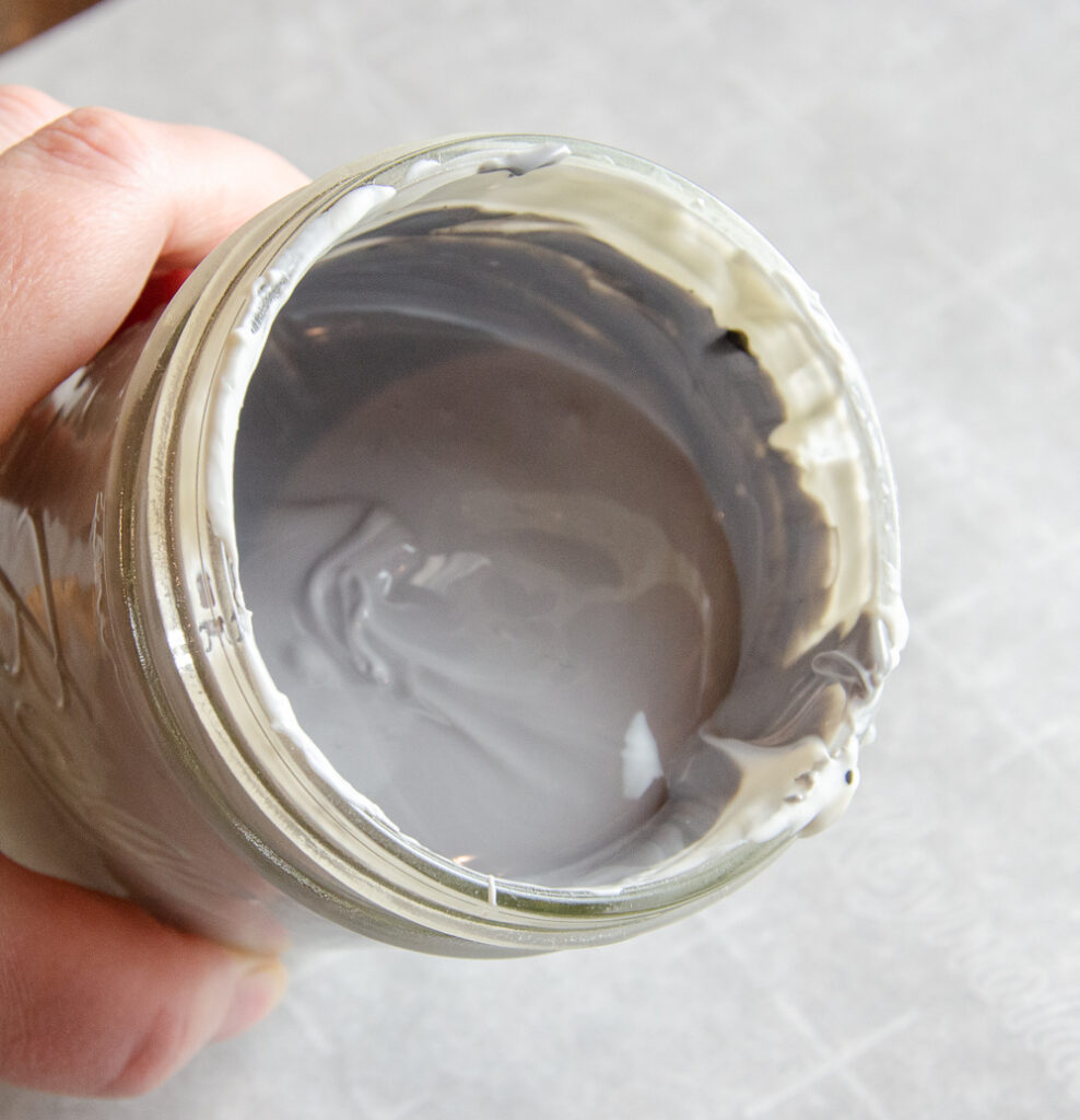 White candy melts dyed with black food coloring, resulting in light gray candy coating instead of black.