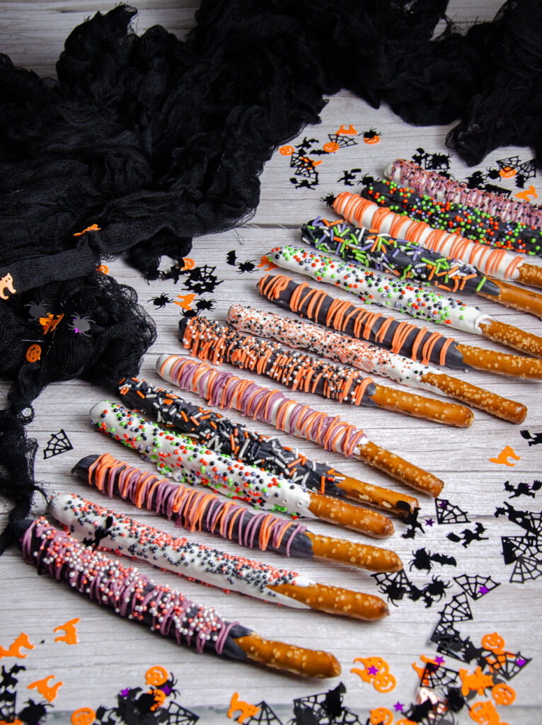Easy Halloween pretzel rods decorated with candy melts, drizzles, and colorful Halloween sprinkles. These festive Halloween chocolate covered pretzels are perfect for parties, classroom treats, and dessert tables.