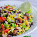 This easy Mexican bean salad is loaded with corn, beans, peppers, and cilantro in a homemade lime dressing. A healthy recipe for summer gatherings.
