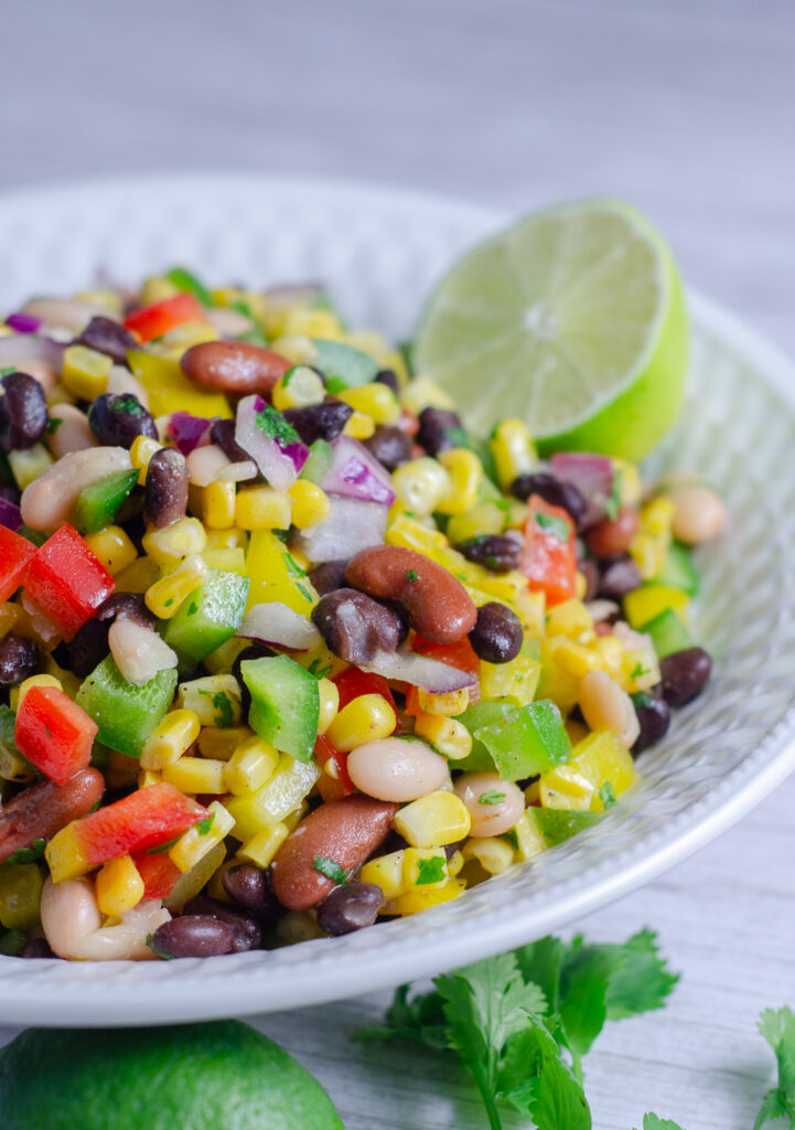 This easy Mexican bean salad is loaded with corn, beans, peppers, and cilantro in a homemade lime dressing. A healthy recipe for summer gatherings.