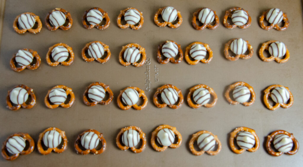 Pretzels with striped Hershey's Kisses on top before going into oven.