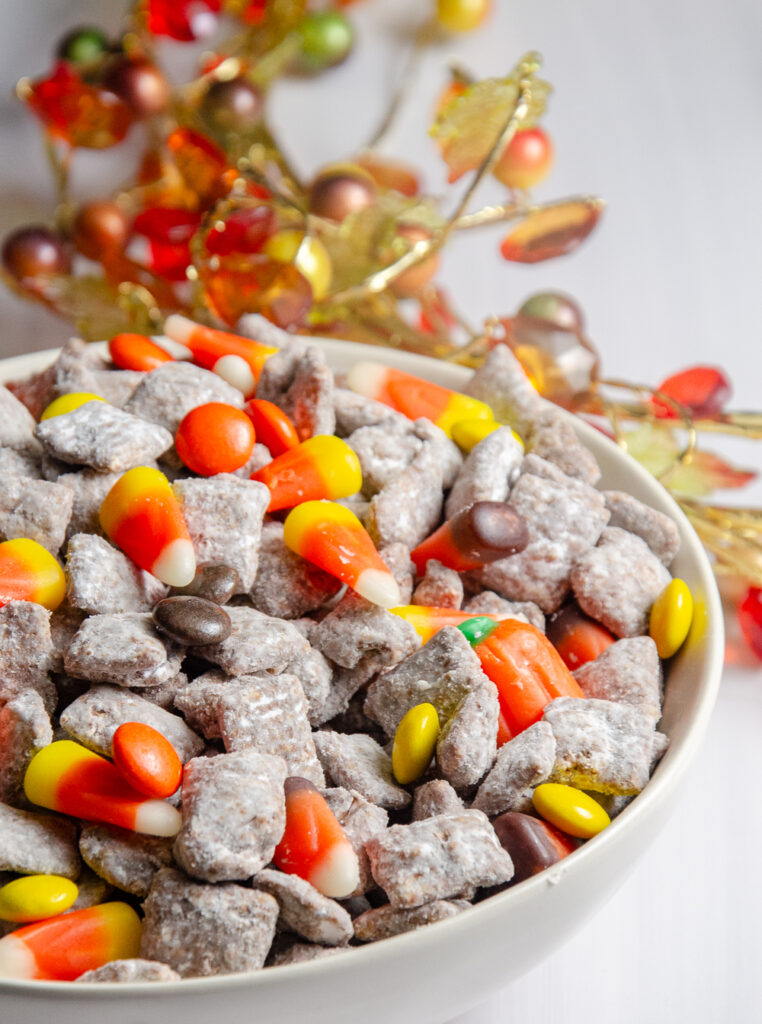 This easy fall puppy chow is an easy autumn twist on classic peanut butter chocolate puppy chow, loaded with Reese’s Pieces, candy corn, harvest candy corn, and candy pumpkins.