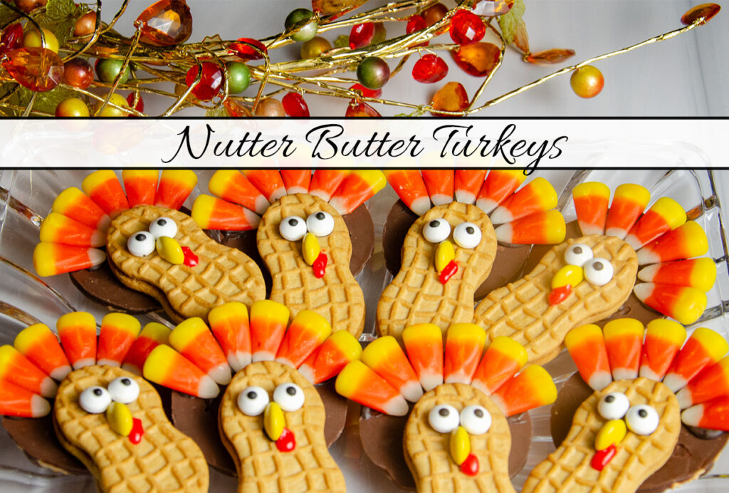Nutter butter turkey cookies arranged on clear plate with fall wire leaf decoration.