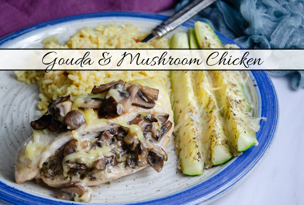 Mushroom and Gouda cheese stuffed chicken breast on white ceramic plate with blue rim. Zucchini sticks and rice pilaf also on plate.